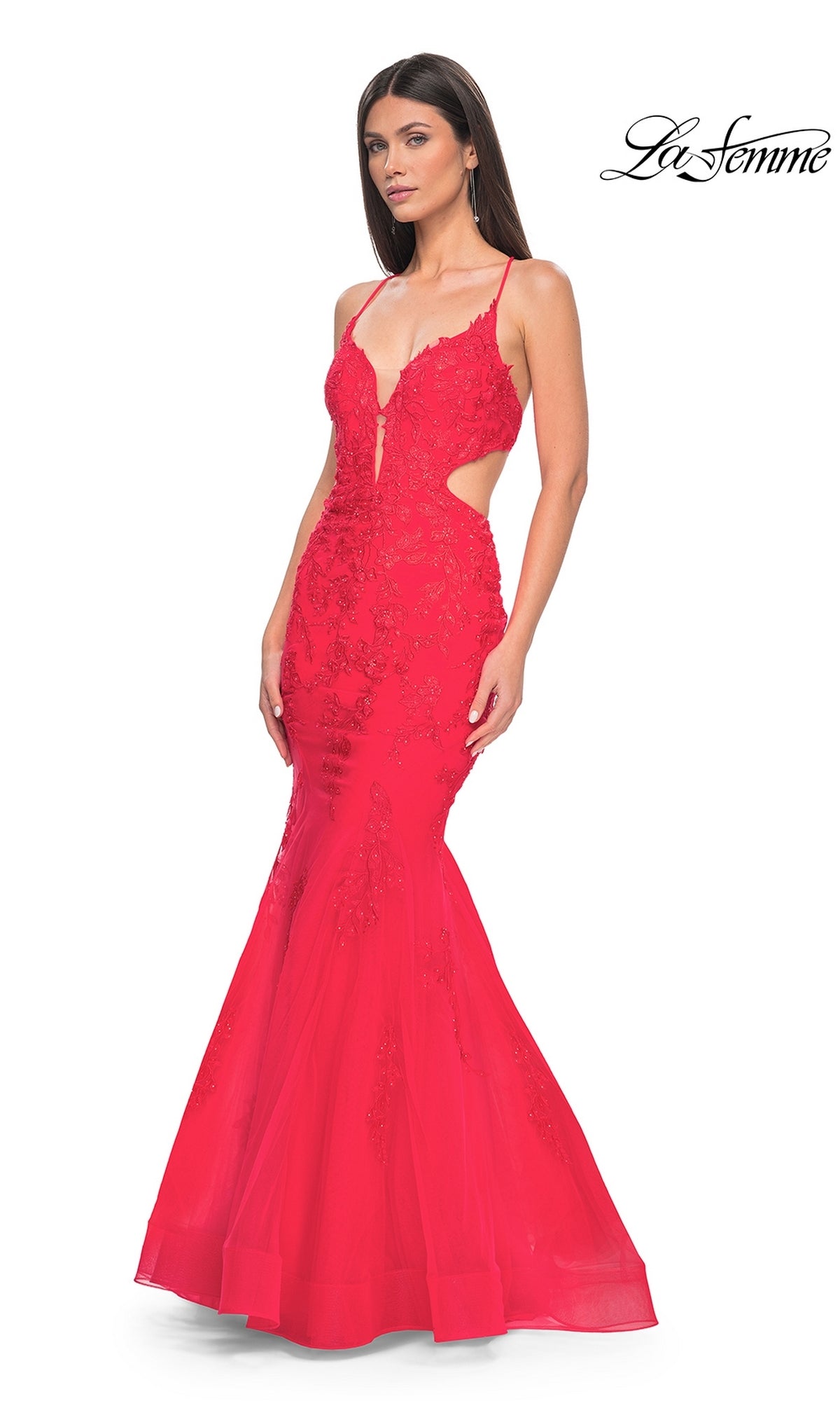 Woman in the La Femme Long Lace Mermaid Prom Dress 31133—a fitted, sleeveless red gown with lace details, side cutouts, and a mermaid skirt.